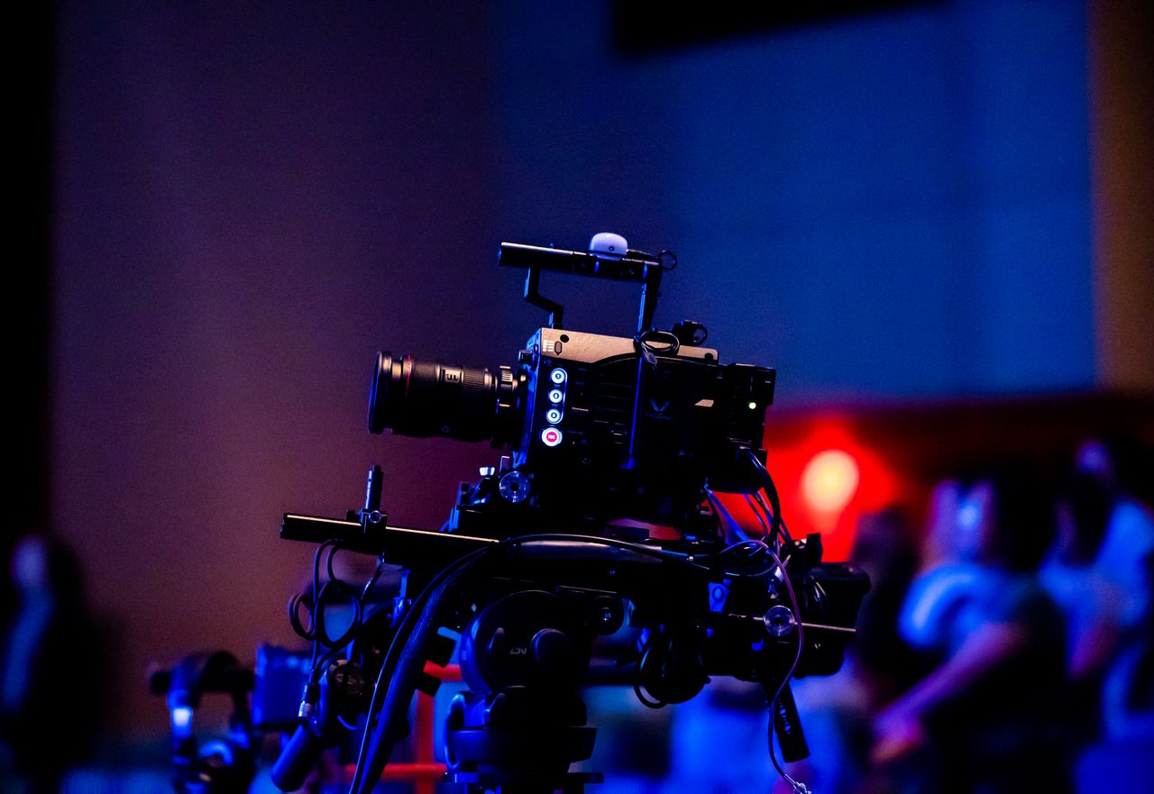 The Art of Drawing Readers In: Your attractive post title goes here A high-quality camera setup capturing a live studio event with an audience in the background.